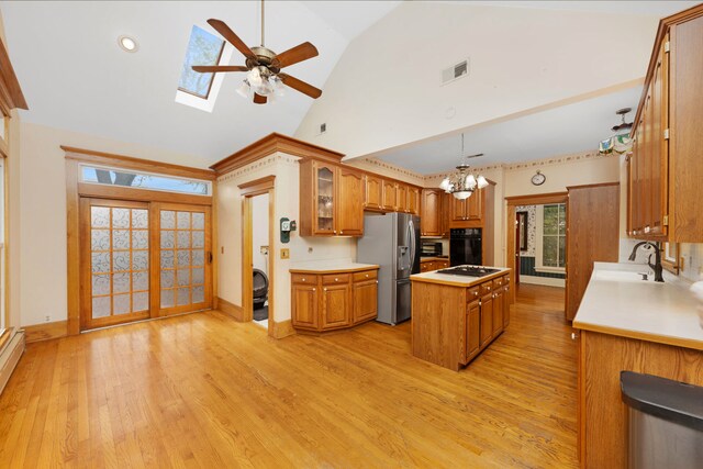 203 High St, West Chicago, IL 60185 - kitchen with stainless steel fridge, oven, a kitchen island, brown cabinetry, and gas stovetop