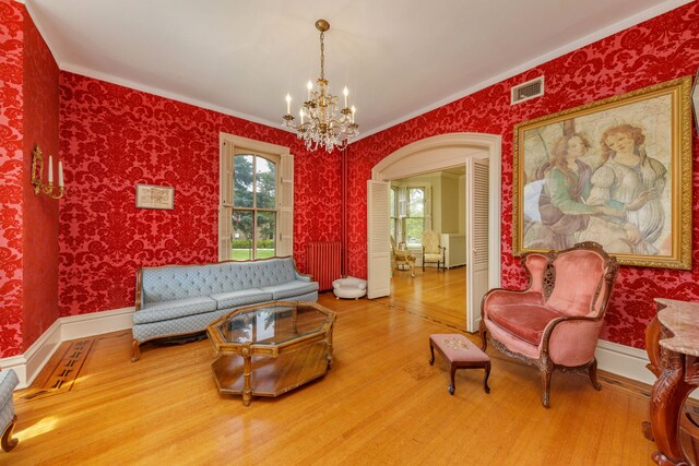 203 High St, West Chicago, IL 60185 - living room featuring wood finished floors, a chandelier, wallpapered walls, crown molding, and baseboards
