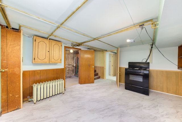 203 High St, West Chicago, IL 60185 - finished basement featuring radiator heating unit, wood walls, wainscoting, and stairs