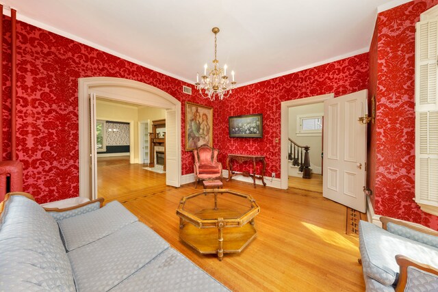 203 High St, West Chicago, IL 60185 - living room with wood finished floors, a chandelier, wallpapered walls, crown molding, and stairs
