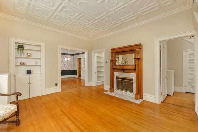 203 High St, West Chicago, IL 60185 - living room with a fireplace, light wood-type flooring, built in shelves, baseboards, and an ornate ceiling