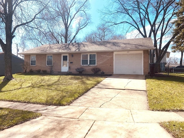 ranch-style home featuring a shingled roof, an attached garage, concrete driveway, brick siding, and a front lawn