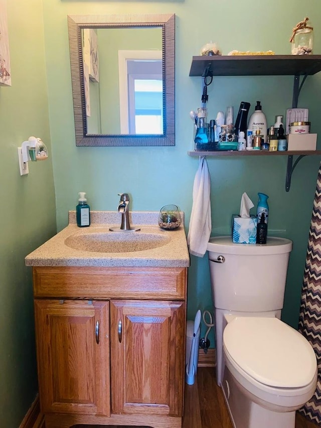 bathroom featuring vanity, toilet, and wood finished floors