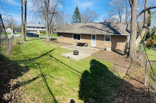 rear view of property with a patio, a yard, fence, and a fire pit
