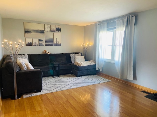 living room featuring light wood-style floors and visible vents