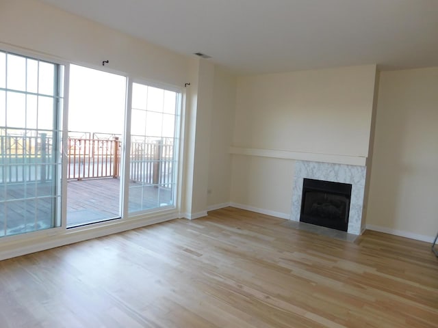 5300 N Lincoln Ave Unit 5A, Chicago, IL 60625 - unfurnished living room featuring light wood-style floors, visible vents, baseboards, and a fireplace