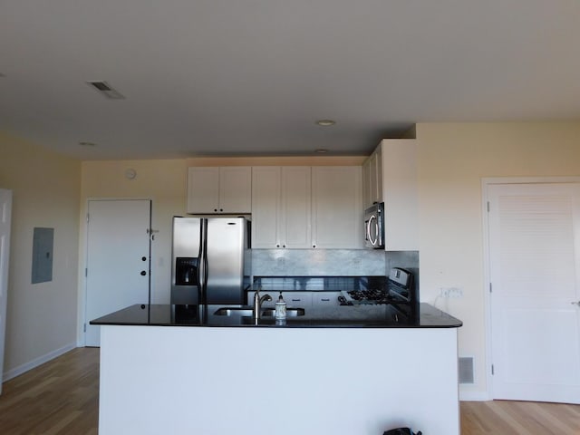 5300 N Lincoln Ave Unit 5A, Chicago, IL 60625 - kitchen featuring dark countertops, a sink, stainless steel appliances, light wood-type flooring, and electric panel