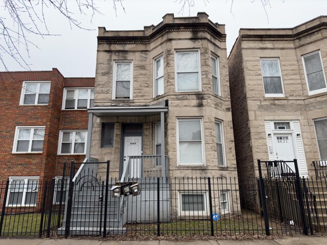 6609 S Rhodes Ave, Chicago, IL 60637 - view of property with stone siding, a gate, and a fenced front yard