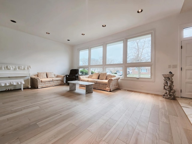 living room with light wood-type flooring and recessed lighting