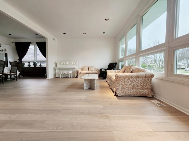 living room featuring light wood-style floors, recessed lighting, visible vents, and baseboards