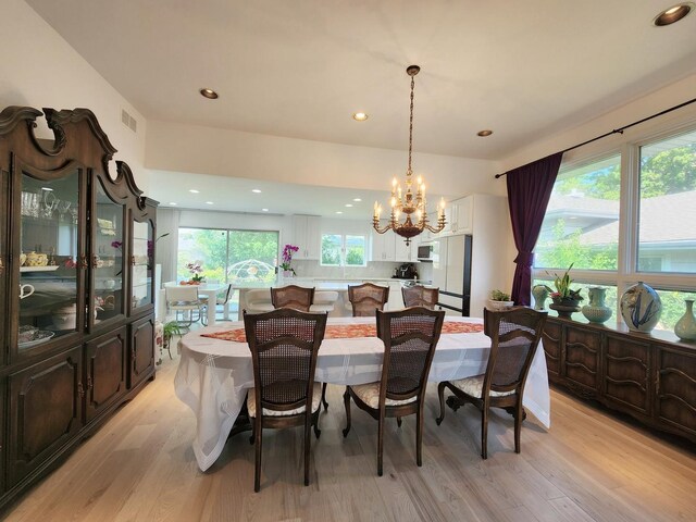 dining area with recessed lighting, light wood finished floors, a notable chandelier, and visible vents