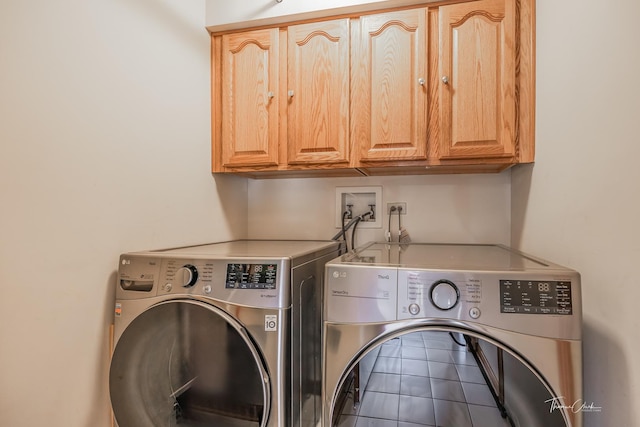 clothes washing area featuring washing machine and dryer and cabinet space