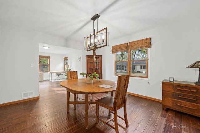 dining area featuring visible vents, baseboards, a notable chandelier, and wood finished floors