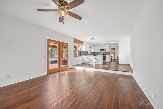 unfurnished living room featuring visible vents, dark wood-style flooring, french doors, and ceiling fan