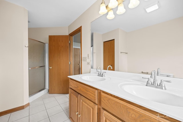 full bathroom featuring a stall shower, double vanity, a sink, and tile patterned flooring