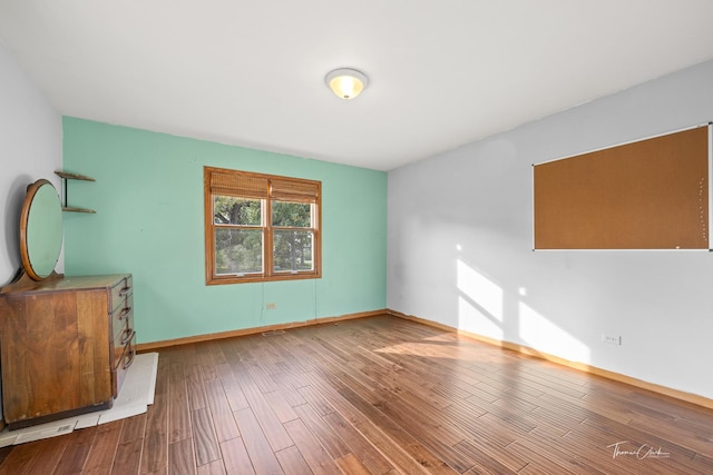 interior space with baseboards and wood finished floors