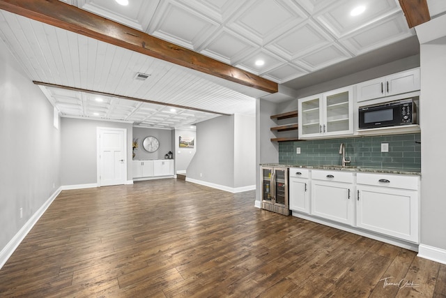 kitchen featuring open shelves, dark wood-style flooring, black microwave, backsplash, and beverage cooler