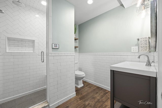 full bath featuring vanity, a stall shower, toilet, tile walls, and wood finished floors