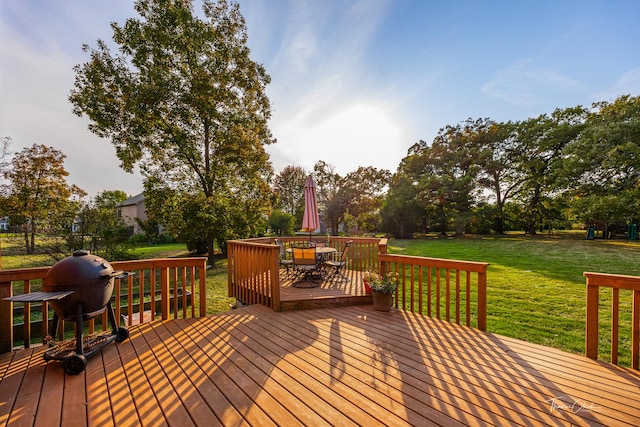 deck featuring area for grilling, a yard, and outdoor dining area