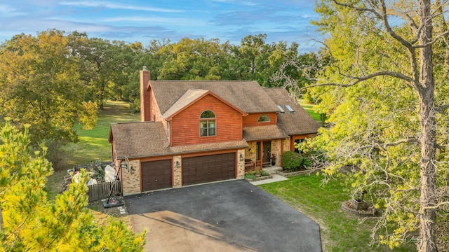 view of front of property with a front yard, brick siding, a garage, and driveway