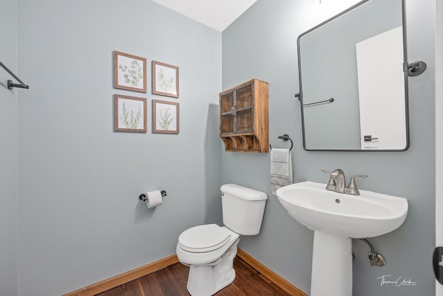 bathroom featuring toilet, wood finished floors, and baseboards