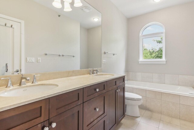 full bath featuring a sink, double vanity, tile patterned flooring, and a garden tub