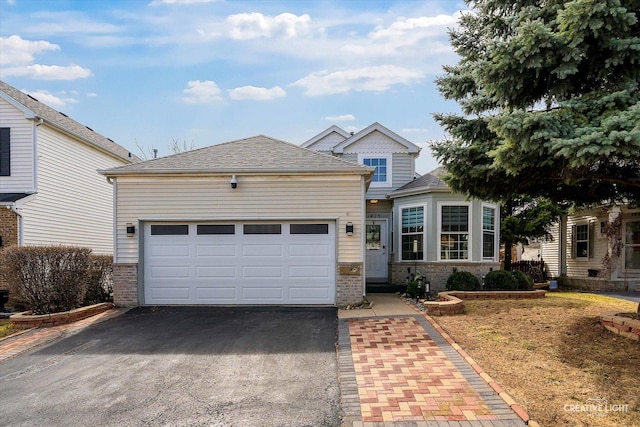 view of front of property featuring an attached garage, a shingled roof, aphalt driveway, and brick siding
