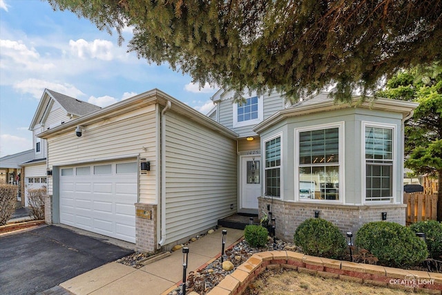view of front of home with a garage, brick siding, driveway, and entry steps