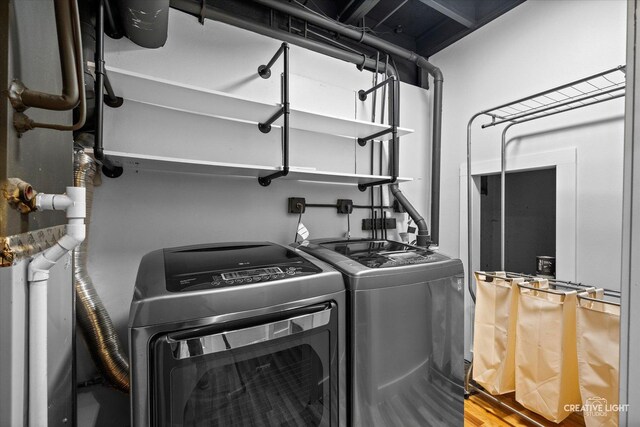 laundry area featuring separate washer and dryer, laundry area, and wood finished floors