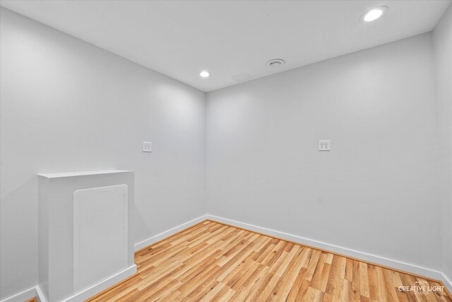 empty room featuring recessed lighting, baseboards, and wood finished floors