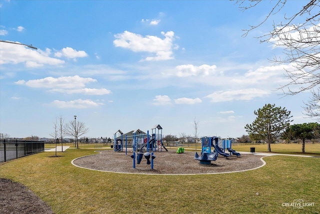 community jungle gym featuring fence and a lawn