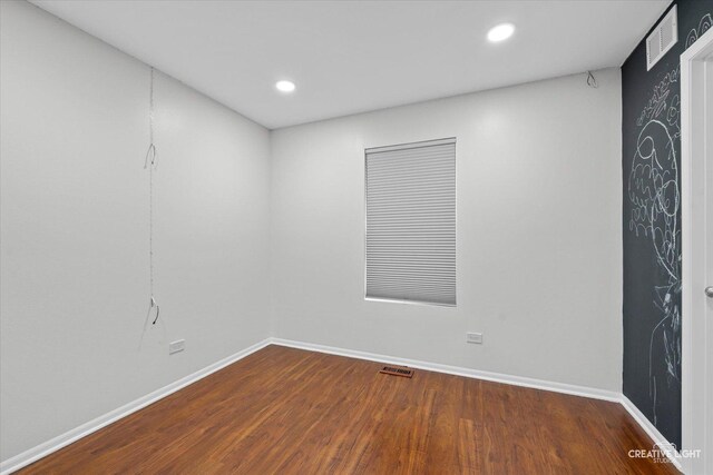 empty room featuring visible vents, baseboards, recessed lighting, and wood finished floors