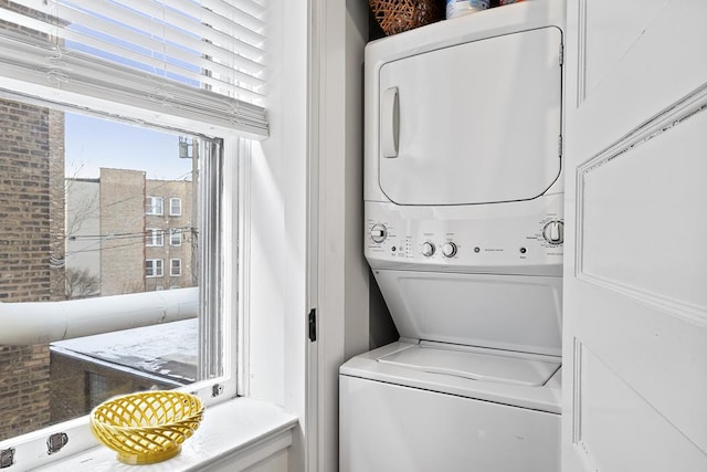 clothes washing area featuring stacked washer and clothes dryer