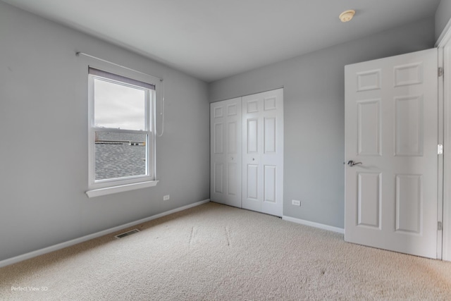 unfurnished bedroom featuring a closet, baseboards, visible vents, and carpet floors