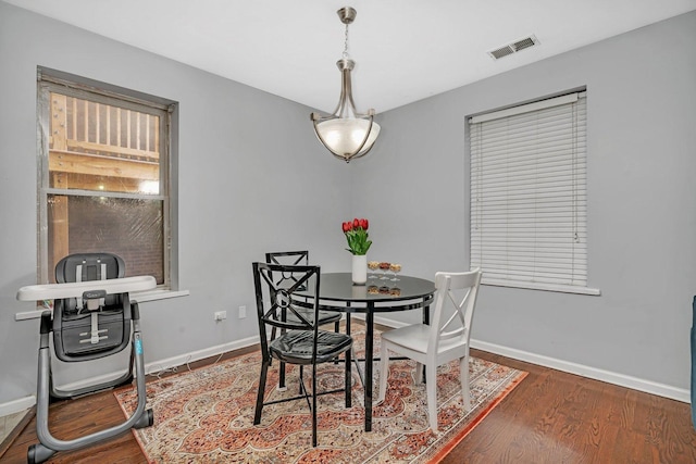 dining room featuring wood finished floors, baseboards, and visible vents