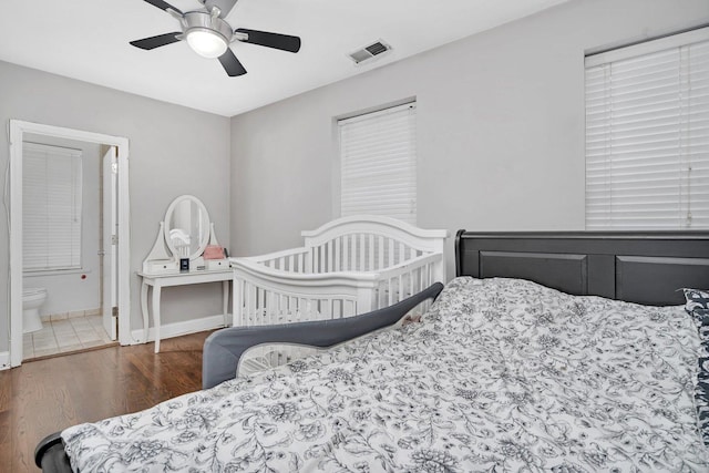bedroom with visible vents, baseboards, a ceiling fan, connected bathroom, and wood finished floors