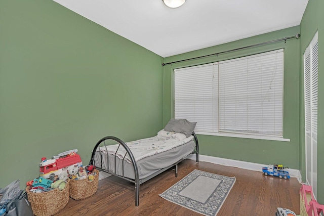 bedroom with baseboards and wood finished floors