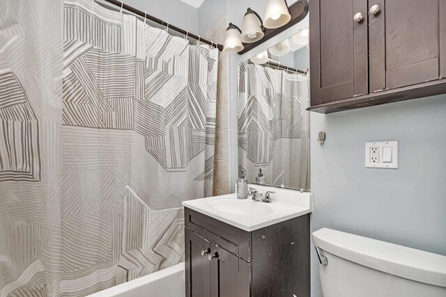 full bath featuring toilet, vanity, and shower / bath combination with curtain