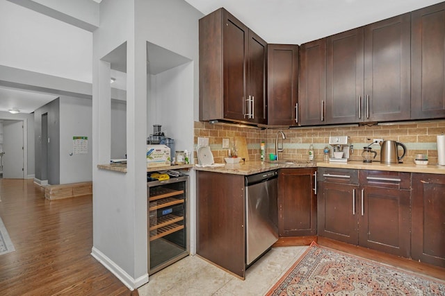 kitchen featuring tasteful backsplash, dishwasher, a sink, dark brown cabinetry, and wine cooler