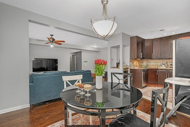 dining area featuring light wood-style flooring, ceiling fan, and baseboards
