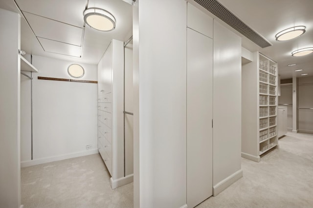 walk in closet featuring light carpet