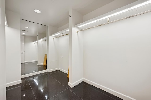 basement with baseboards, recessed lighting, and granite finish floor