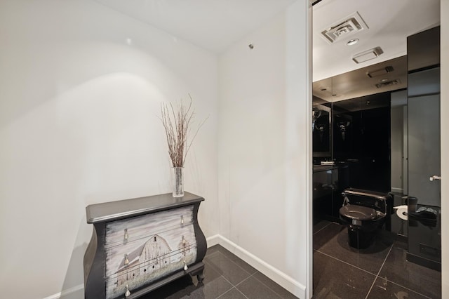 hallway with baseboards and visible vents