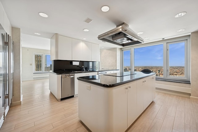 kitchen featuring stainless steel dishwasher, exhaust hood, white cabinetry, dark countertops, and black electric stovetop