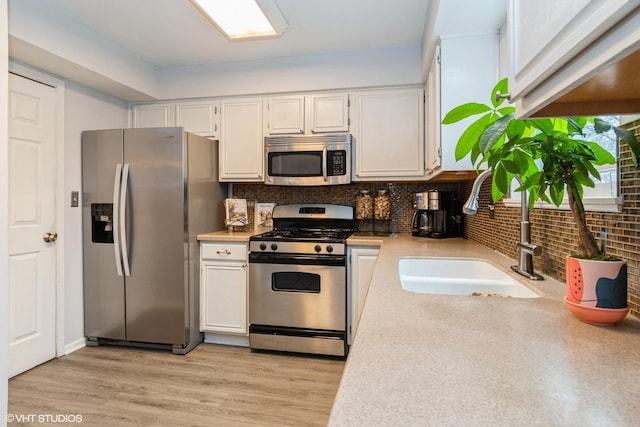1164 Lakewood Cir, Naperville, IL 60540 - kitchen featuring appliances with stainless steel finishes, a sink, light countertops, white cabinets, and backsplash