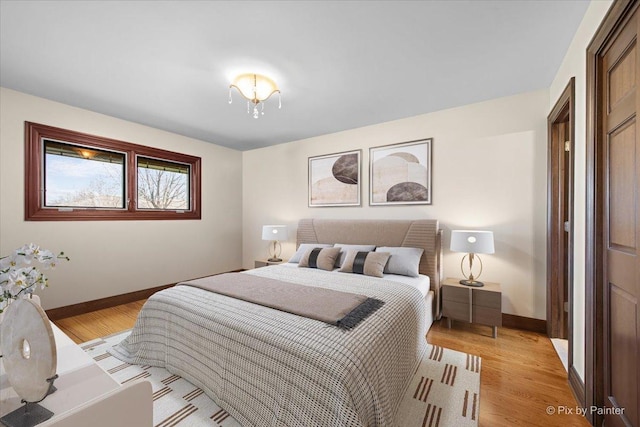 bedroom with light wood-style flooring and baseboards