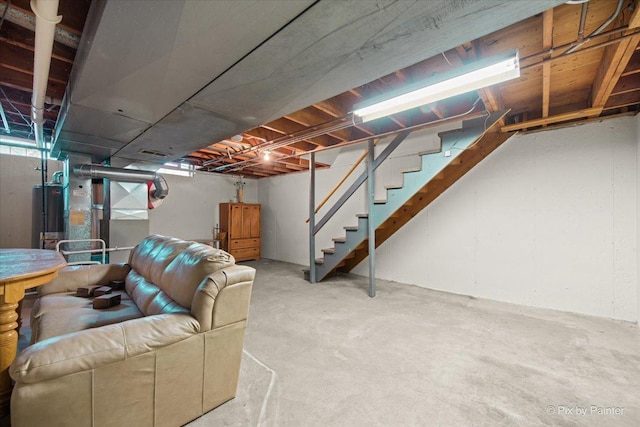 unfinished below grade area featuring water heater and stairs