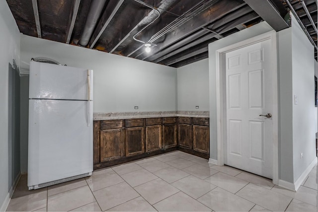 kitchen with freestanding refrigerator and dark brown cabinets