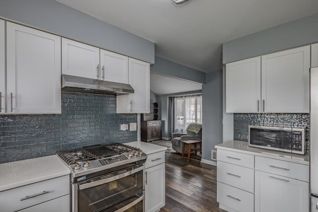 kitchen with white cabinets, light countertops, range with two ovens, under cabinet range hood, and dark wood-style floors