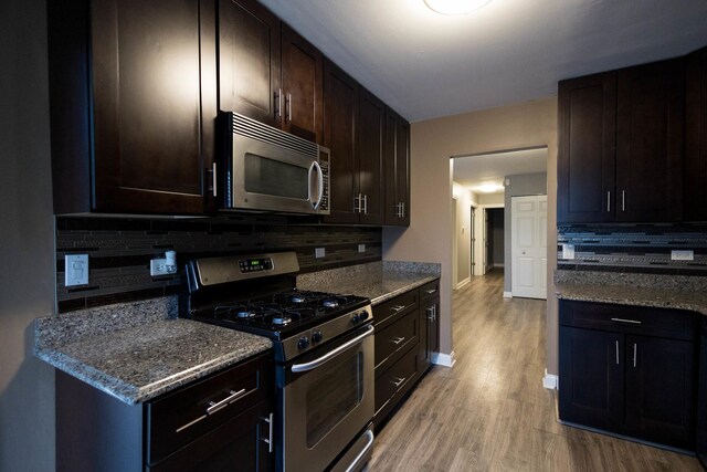 9132 Clairmont Ct Unit 113, Orland Park, IL 60462 - kitchen featuring light wood-style floors, dark brown cabinetry, stainless steel appliances, decorative backsplash, and baseboards